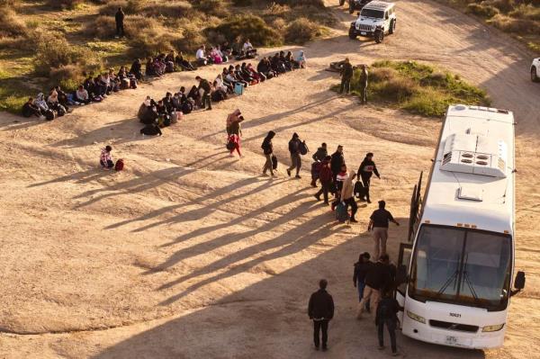 Migrants getting on a bus. 