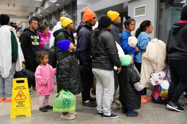 Migrants wait on line. 