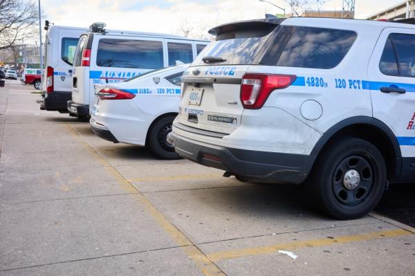 NYPD vehicles parked on a sidewalk outside of the 120th Precinct on State Island on April 12, 2024.