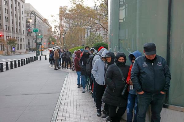 Migrants lined up outside a building