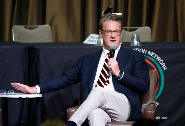 Joe Scarborough sitting in a chair and speaking into a microphone