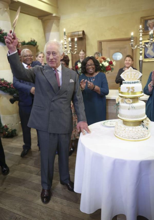 Britain's King Charles III prepares to cut a cake as he hosts his 75th birthday party at Highgrove Gardens.