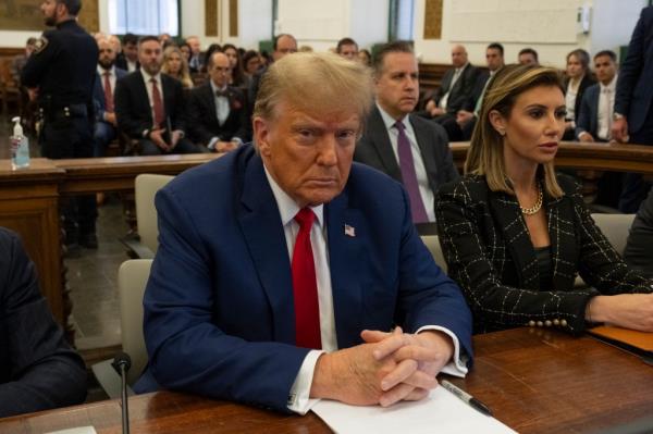 Do<em></em>nald Trump sitting at the defense table in the courtroom.