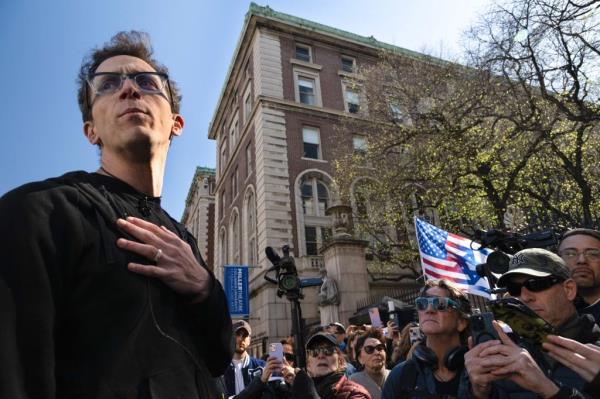 Assistant Professor Shai Davidai holding a press co<em></em>nference in front of Columbia University's gates, surrounded by pro-Israel demonstrators