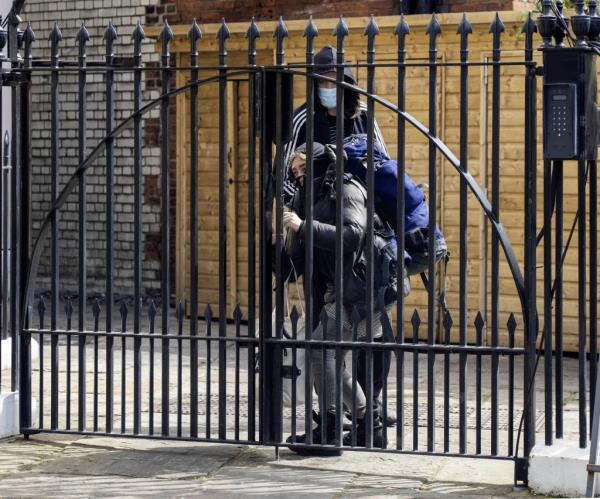 An alleged squatter leaves the York and Albany restaurant in Camden as her friend secures the gate with a bike lock on April 13, 2024.