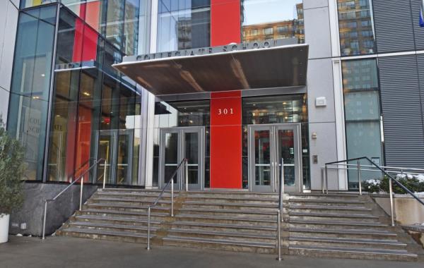 Exterior view of The Collegiate School at 301 Freedom Place South, New York, showing a building with glass doors and stairs