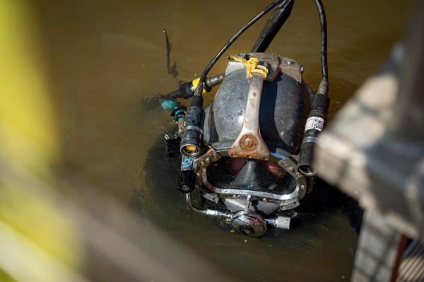 A marine archeologist submerges into the Mobile River to investigate the remains of the Clotilda.