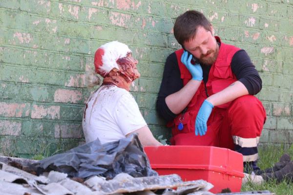 A medic helps an injured local resident at the site of a residential area hit by a Russian missile strike in Kyiv region, Ukraine January 16, 2023.