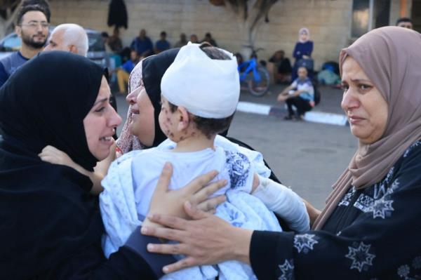 A woman hold a injured toddler following the Israeli bombardment of Deir Balah in the central Gaza Strip, at the Shuhada Al-Aqsa hospital in the same city on November 6, 2023,