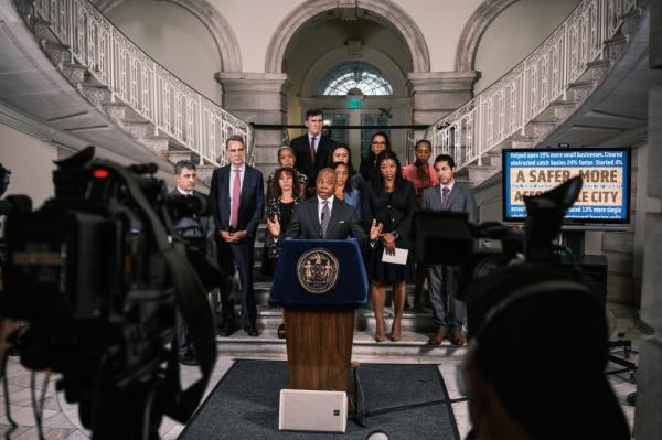 Eric Adams flanked by administration at a press conference.