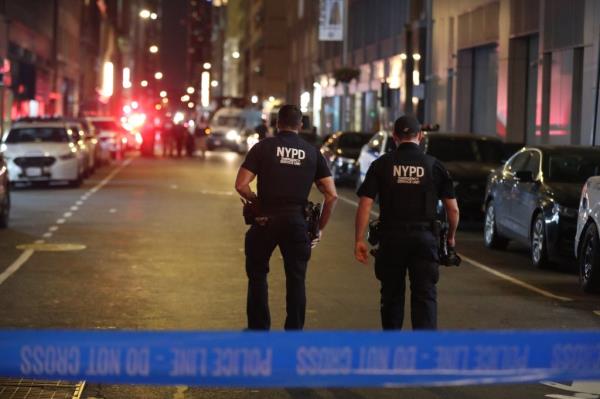 Two NYPS officers walk down street. 