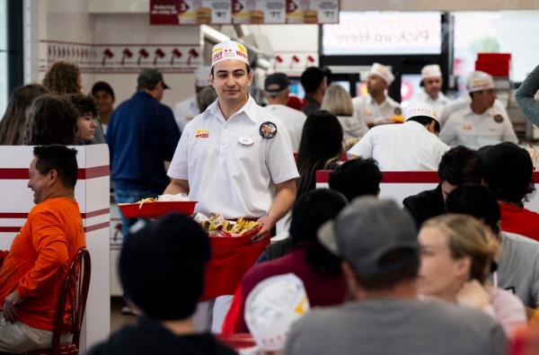 Employee serves diners at In N Out location in San Juan Capistrano, CA on Dec. 7, 2023.