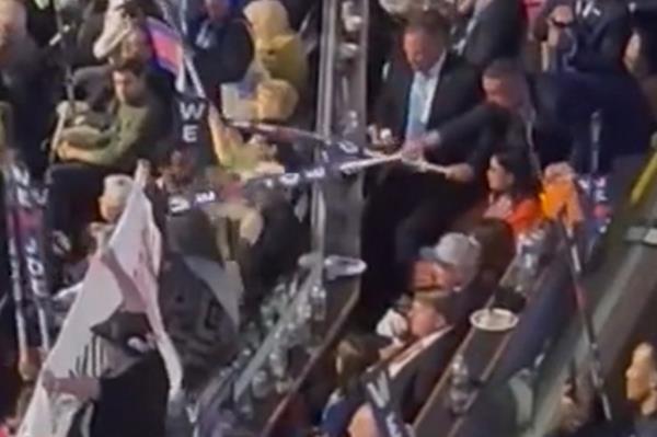 Screenshot: The woman, who was wearing a hijab, had just unveiled a “Stop Arming Israel” banner in the crowded Chicago arena when a man standing several rows behind started whacking her with his pro-Biden sign on Mo<em></em>nday night. 