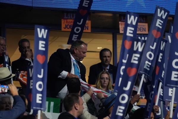 A protest banner is removed by a law enforcement officers as President Joe Biden speaks during the Democratic Natio<em></em>nal Co<em></em>nvention Monday, Aug. 19, 2024, in Chicago.