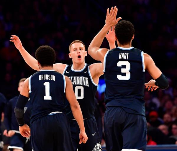 Do<em></em>nte DiVincenzo high fives his teammates Jalen Brunson and Josh Hart.