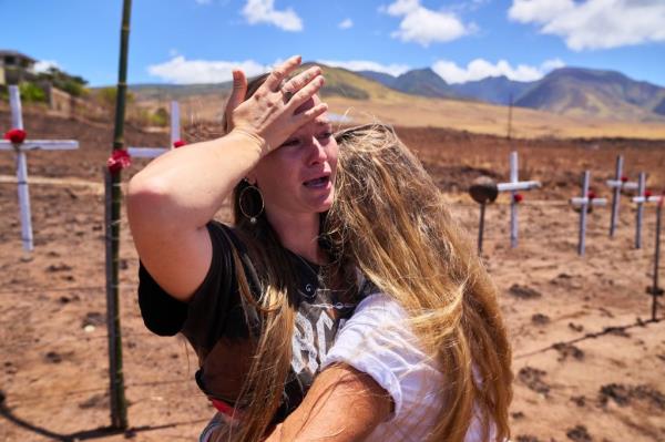 Tattoo parlor owner Shelby Schweitzer, left, is comforted by her mother Shawnee Schweitzer.