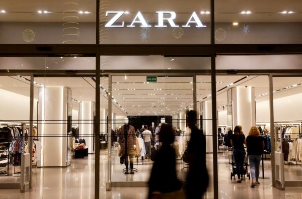 Shoppers walking past a Zara store front in Las Palmas de Gran Canaria, Spain.