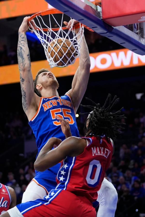 New York Knicks' Isaiah Hartenstein, left, dunks against Philadelphia 76ers' Tyrese Maxey.