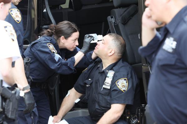 An injured cop is attended to after being assaulted in a Manhattan parking garage in May. 