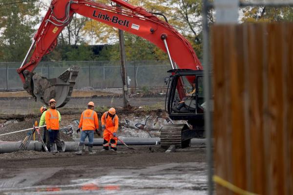 Work goes on as dozens of protesters demand a stop to the proposed tent city for migrants at 38th Street and California Avenue in Chicago on Oct. 19, 2023.