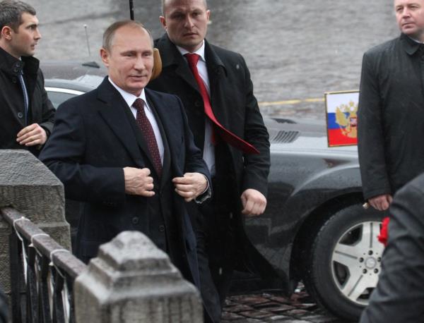 Russian President Vladimir Putin (L) surrounded by bodyguards attends a wreath laying ceremony at the mo<em></em>nument of Minin and Pozharsky in Red Square on November, 4, 2013 in Moscow
