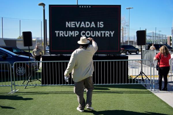 a person takes a picture of a screen with Do<em></em>nald Trump speaking at a campaign event in Las Vegas