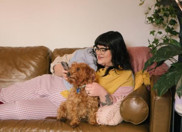 Woman relaxing at home with her dog on the couch