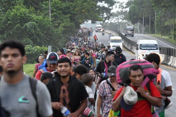 A caravan of migrants walks along a road in Tapachula on its way to the US-Mexico border on Oct. 31, 2023.
