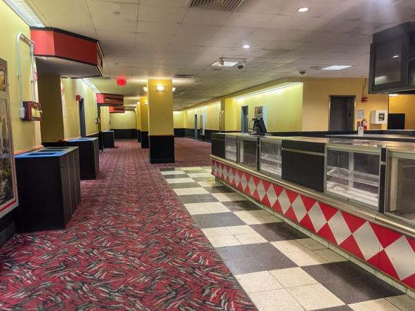 A long view of a theater floor and a now-defunct co<em></em>ncession stand.