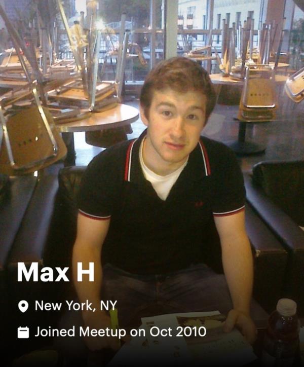 max hartman in a black short sleeved shirt sitting in a restaurant wher<em></em>e the tables behind him had the chairs upside down on top of them