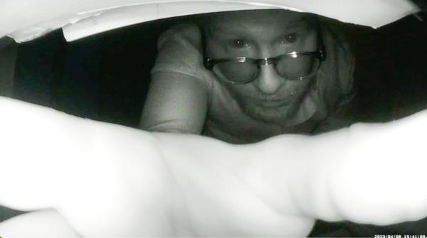 Hartman peers into the camera and adjusts it.