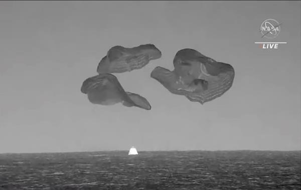 A SpaceX capsule, slowed by parachutes, splashes down in the Atlantic Ocean off the Florida coast on Sept. 4, 2023, as it returns to Earth. 