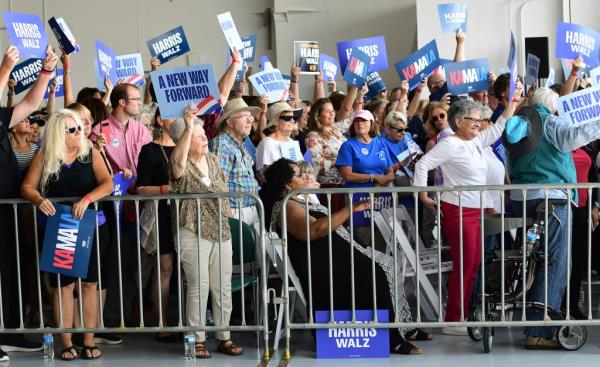 Supporters holding signs for Democratic presidential nominee Vice President Kamala Harris at the John Murtha Johnstown-Cambria County Airport, including celebrity Maria Rita Rossa