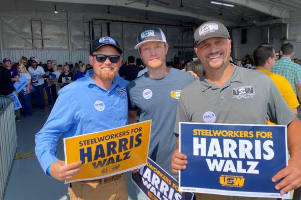 Greg Dudara, a United Steelworkers unio<em></em>n official and Kamala Harris supporter, holding a sign at Harris's airport arrival with a group of men.