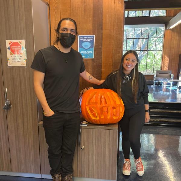 Gabriel Trujillo and Roxanne Cruz-de Hoyos stand near a pumpkin