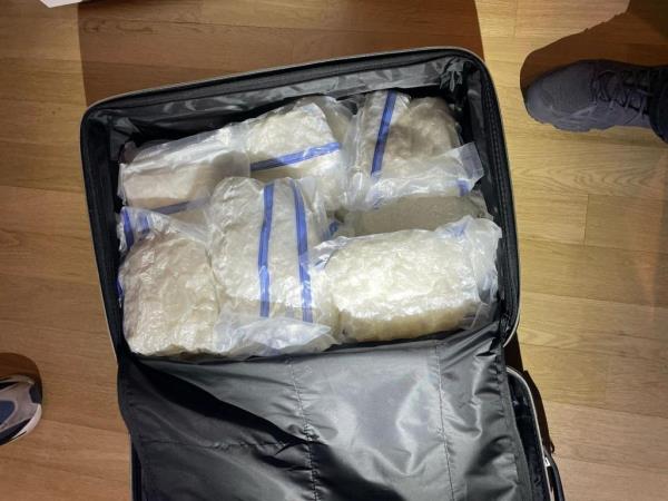 A suitcase co<em></em>ntaining several clear plastic bags of drugs.