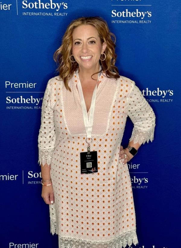 Photo of a white woman wearing a white eyelet dress and black pass around her neck with a blue background that says, 