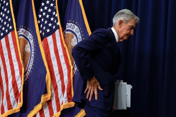 U.S. Federal Reserve Chair Jerome Powell speaking during a press co<em></em>nference in Washington, with flags in the background.