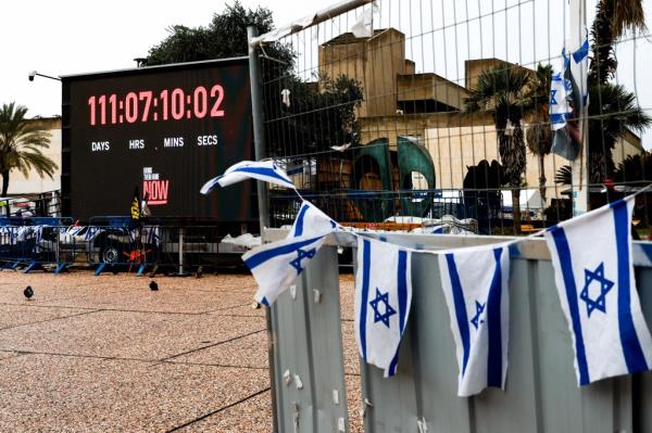 Israeli flags flutter near a large electro<em></em>nic screen counting the time since Israeli hostages were taken by Hamas gunmen on Oct. 7. 