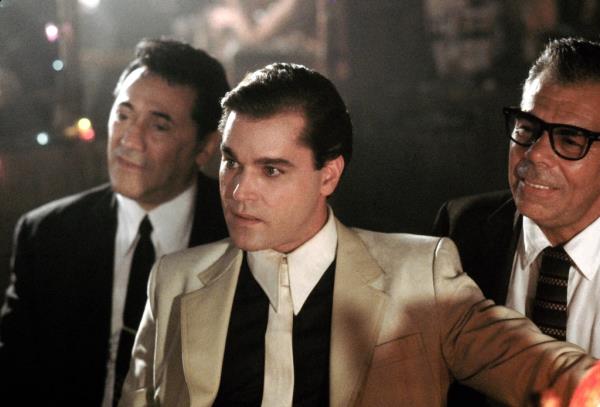 Actors Frank Adonis, Ray Liotta, and John Manca in a scene from the movie Goodfellas, all dressed in suits.