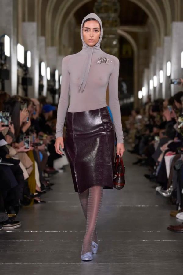 A model on Tory Burch runway wearing a mo<em></em>nochromatic outfit accessorized with a matching brooch