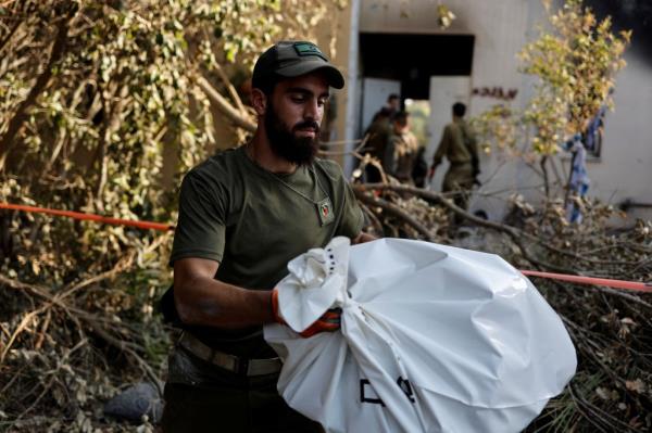 An Israeli soldier carries a bag co<em></em>ntaining human remains