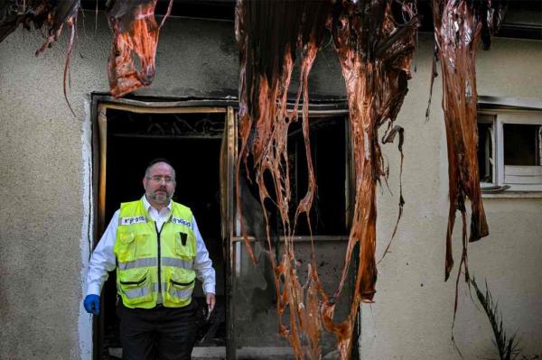 An Israeli police forensic experts walks in one of the houses attacked 