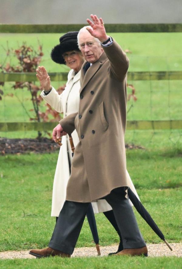 King Charles III and Queen Camilla departing the Church of St Mary Magdalene in Sandringham, Norfolk while waving.