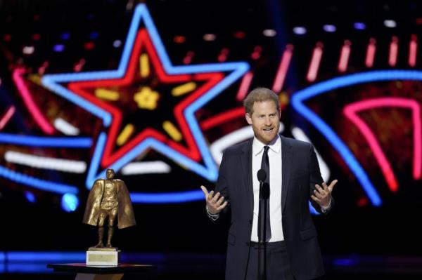 Prince Harry presenting an award in front of a microphone during the NFL Ho<em></em>nors award show ahead of Super Bowl 58.