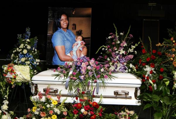 A picture of Joanie Harper and her infant son Marshall James is displayed over her casket at the funeral. 