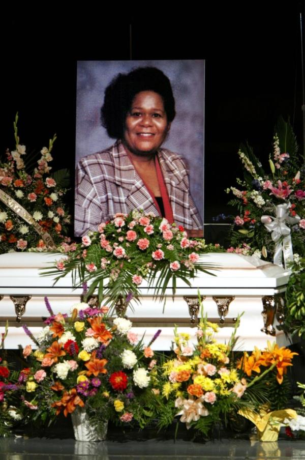 A picture of Earnestine Harper is displayed over her casket at the funeral for her and four family members