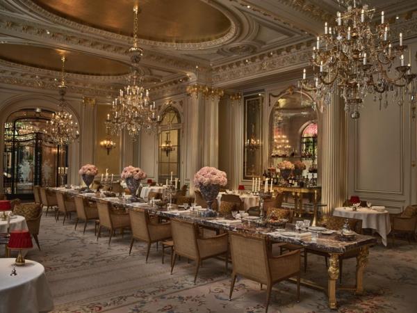 Interior of the Hotel Plaza Athenee in Paris, featuring large room with chandeliers and tables