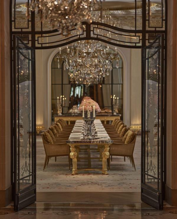 Inside view of the chic Hotel Plaza Athenee in Paris, featuring a dining room with chandeliers and tables, popular among celebrities.