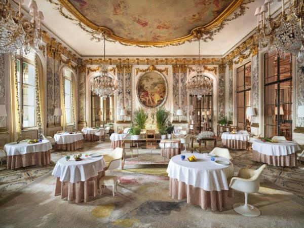 Luxurious interior of Le Meurice, the original Parisian Palace hotel, featuring room with tables and chairs
